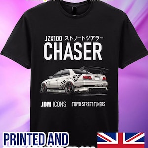 Könnte beinhalten: Schwarzes T-Shirt mit weißer Grafik eines JDM Chaser Autos und Text. Der Text enthält "JZX100 ストリートツアラー CHASER", "JDM ICONS" und "TOKYO STREET TUNERS". Erhältlich in verschiedenen Größen.