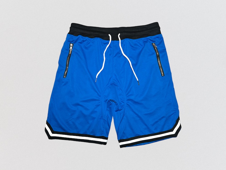 May include: Blue athletic shorts with black and white trim. The shorts have two zippered pockets and a white drawstring.