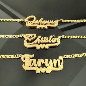 May include: Three gold necklaces with personalized names, "Johanna", "Christen", and "Taryn", each with a small heart charm. The necklaces are on a black background.