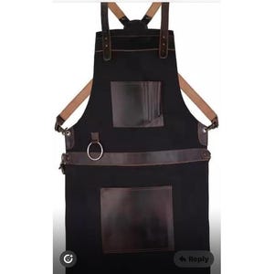 Puede incluir: Delantal negro con detalles en cuero marrón, incluyendo bolsillos y correas. Cuenta con un anillo metálico y correas ajustables. Ideal para cocinar, manualidades u otras actividades.