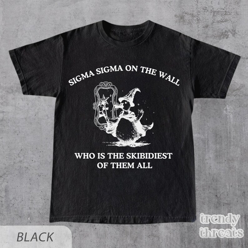 May include: Black t-shirt featuring a white graphic of a wizard holding a mirror with the text "Sigma Sigma on the wall, who is the Skibidiest of them all".