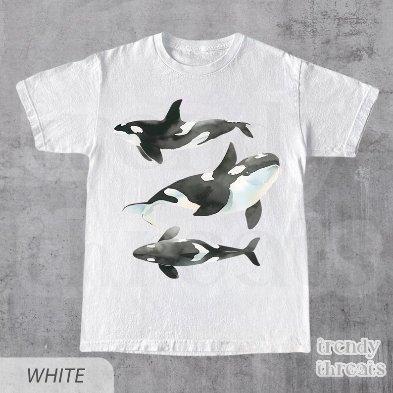 May include: White t-shirt with a graphic of three black and white orcas swimming. The text "trendy threads" is printed in the bottom right corner.