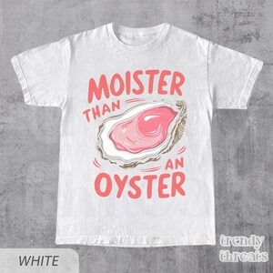 May include: White t-shirt with a pink oyster graphic and the text "Moister than an oyster".