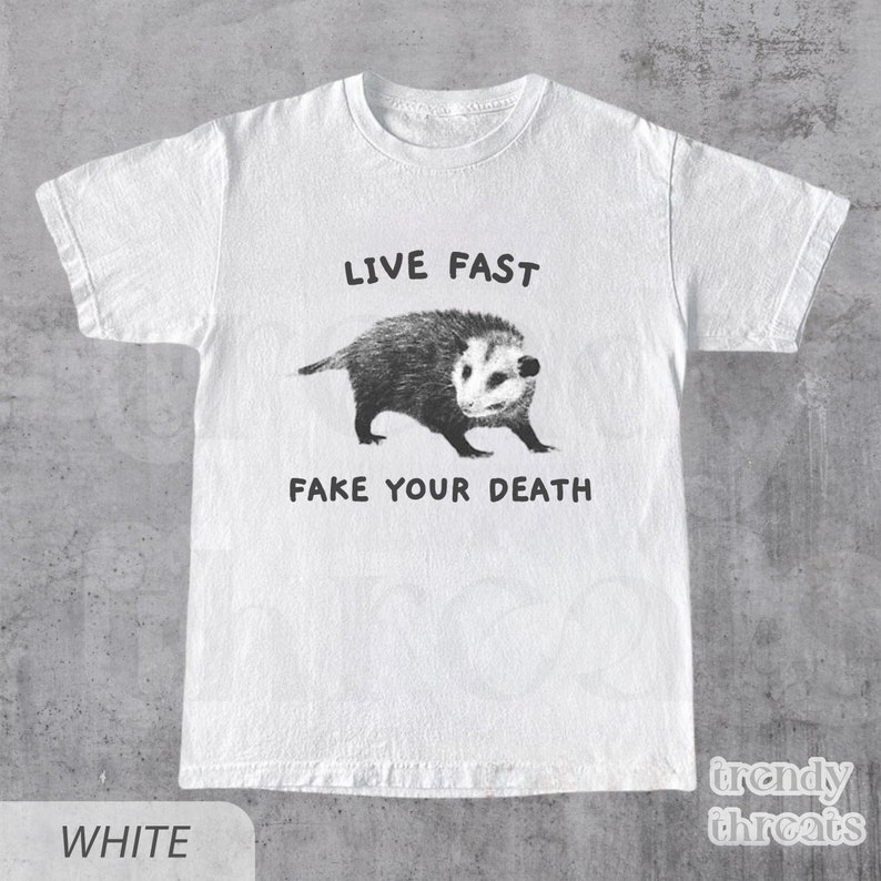 May include: White t-shirt with a black and white illustration of a possum and the text "Live Fast Fake Your Death."