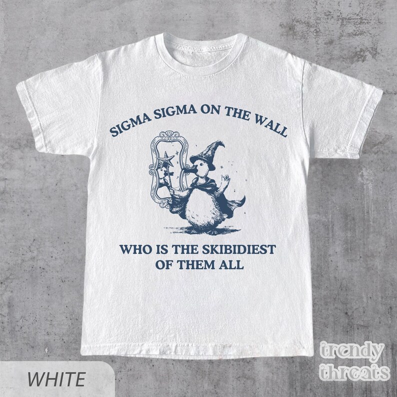May include: White t-shirt featuring a blue illustration of a penguin wearing a wizard hat and holding a wand. The text "Sigma Sigma on the wall" and "Who is the Skibidiest of them all" is printed on the shirt.