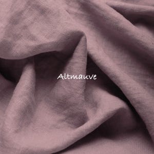 May include: A piece of fabric in a dusty mauve color with a visible woven texture and soft folds. The word Altmauve is printed in white text in the center of the fabric, indicating the specific color shade of this textile material.