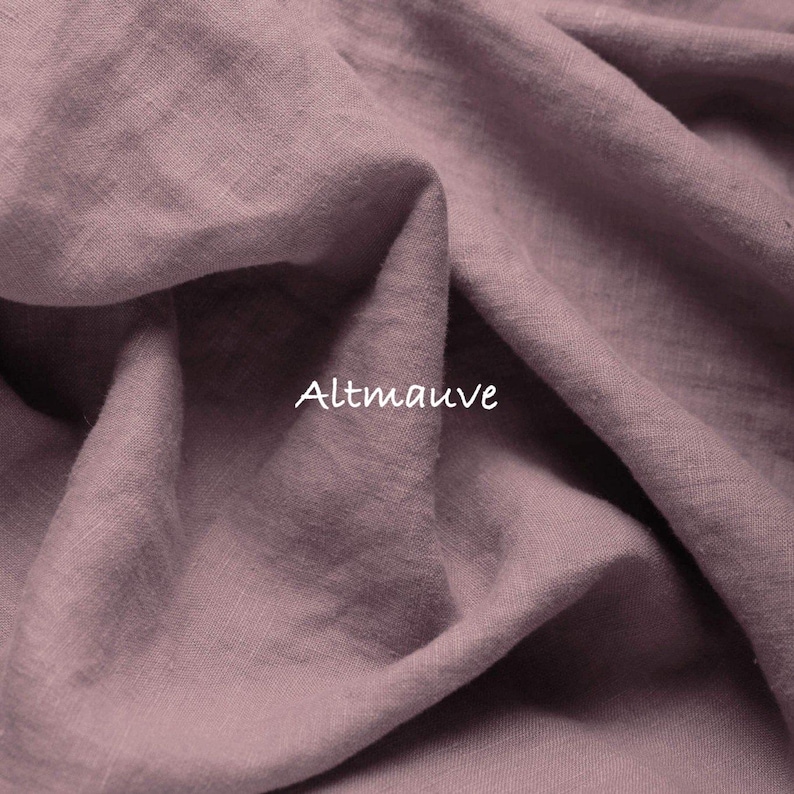 May include: A piece of fabric in a dusty mauve color with a visible woven texture and soft folds. The word Altmauve is printed in white text in the center of the fabric, indicating the specific color shade of this textile material.
