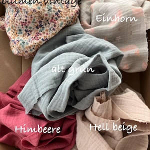May include: A collection of five fabric remnants in a cardboard box, including floral, unicorn print, sage green, raspberry, and beige pieces. Text on the image reads Reststoff-Paket, blumen vintage, Einhorn, alt grün, Himbeere, Hell beige, 5 Stück Grösse 20cmX60cm.