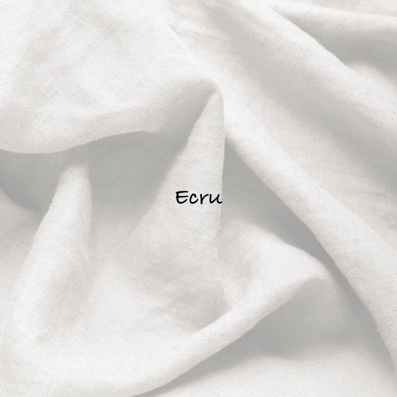 May include: A piece of white fabric with a visible woven texture and soft folds. The word Ecru is printed in black, sans-serif lettering in the center of the fabric. The material appears lightweight and has a matte finish throughout the surface.