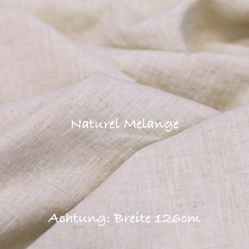 May include: A piece of light beige fabric with a visible woven texture and folds. The text Naturel Melange is printed on the fabric, along with the text Achtung: Breite 126cm, indicating a width of 126 centimeters for this textile material.