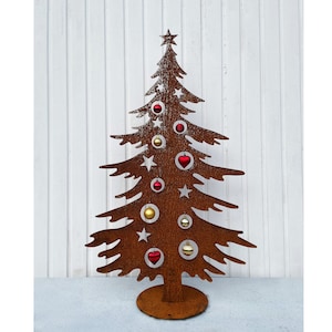 Peut inclure: Décoration de sapin de Noël en métal rouillé, ornée d'une étoile au sommet et d'étoiles découpées. Le sapin est décoré de boules rouges, dorées et en forme de cœur. Il repose sur une base ronde, sur fond blanc.