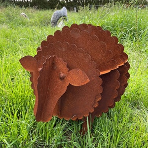Peut inclure: Sculpture de mouton en métal brun rouillé dans un champ herbeux. Le mouton présente un design détaillé et superposé pour sa laine et une tête simple. C'est une décoration de jardin.