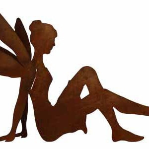 Può includere: Una silhouette di fata in metallo arrugginito con le ali, seduta con una gamba estesa. La fata è rivolta a destra.