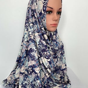 May include: A blue and white floral patterned hijab. The hijab is made of a soft, stretchy fabric and is perfect for everyday wear.