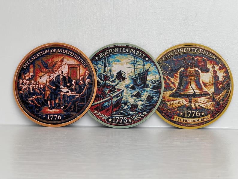 May include: Three round coasters with historical American scenes. One depicts the Declaration of Independence, another the Boston Tea Party, and the third the Liberty Bell. Each coaster has the year 1776 or 1773.