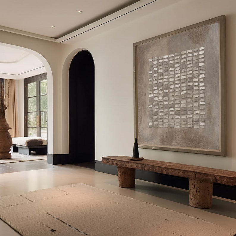 May include: A long, rustic wooden bench with two thick, tree trunk legs sits in a modern hallway with white walls and a large abstract painting above it.