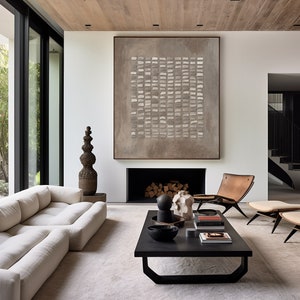 May include: A modern living room with a white sofa, a black coffee table, and a brown leather armchair. A large abstract painting hangs above a fireplace. The room has a light and airy feel.