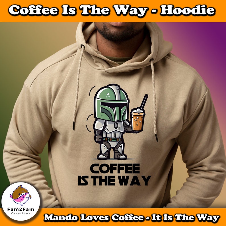 Puede incluir: Una sudadera con capucha de color beige con una imagen de dibujos animados de un personaje mandaloriano sosteniendo una taza de caf&eacute;. El texto "COFFEE IS THE WAY" est&aacute; impreso debajo de la imagen. El texto "Mando Loves Coffee - It Is The Way" est&aacute; impreso en la parte inferior de la sudadera.