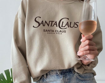 Sudadera navideña minimalista con diseño de Papá Noel en el Polo Norte, inspirada en el lujo.