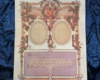 Puede incluir: Un certificado de matrimonio de estilo vintage con un borde ornamentado de ilustraciones florales, un querubín central y dos marcos ovalados para fotos. El texto dice Marriage Certificate, Were this day of legally joined by me in MATRIMONY.