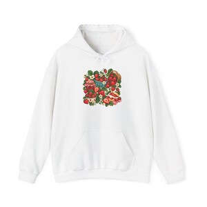 May include: A white hooded sweatshirt featuring a central graphic illustration of red strawberries, green leaves, white blossoms, a small woven basket, a glass jar with a red checkered lid, and a pastry topped with cream and fresh strawberries.