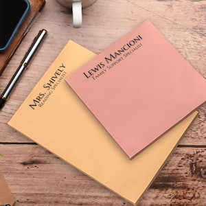 May include: Two yellow and pink sticky note pads with black text. The top pad reads "Lewis Mancioni Family Support Specialist" and the bottom pad reads "Mrs. Shively Reading Specialist".