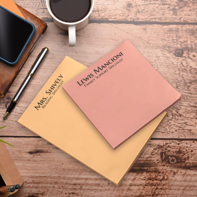 May include: Two yellow and pink sticky note pads with black text. The top pad reads "Lewis Mancioni Family Support Specialist" and the bottom pad reads "Mrs. Shively Reading Specialist".