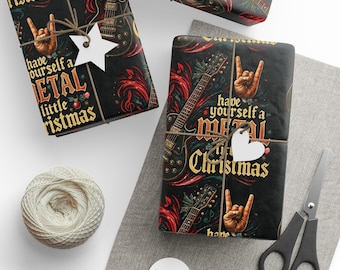 Puede incluir: Papel de regalo negro con guitarras eléctricas, notas musicales rojas y manos haciendo un gesto de rock. El texto dice, Have yourself a metal little Christmas, en letras doradas. Incluye etiquetas de regalo blancas de estrella y corazón.