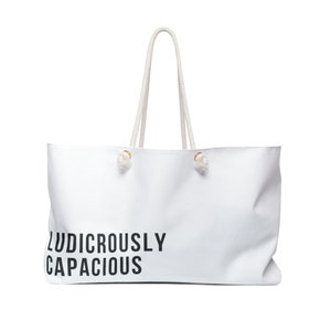 May include: White canvas tote bag with white rope handles and the text "Ludicrously Capacious" printed in black.
