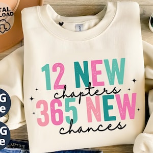 Può includere: Felpa color crema con la scritta "12 NEW chapters 365 NEW chances" in verde acqua e rosa. Il design include stelle nere ed è un file digitale SVG e PNG.