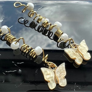 May include: Two gold hair coils with white beads and white butterfly charms.