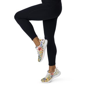 Women's Watercolor Wildflowers Sneakers : Athleisure Casual Shoes, Lightweight, Lace-up, Floral, Flowers. Vibrant watercolor wildflowers in shades of orange, blue, yellow, and pink, with green leaves and foliage, against a crisp white background. Bright white inner and outer soles, trim and shoelaces. The upper is a ultralight knit weave. These casual shoes are perfect for travel, shopping, running errands or just hanging out. Super lightweight and comfortable.