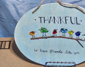 Thankful to have friends like you sign. Made with glass pieces on a thin wood plaque. Comes with rope for hanging.