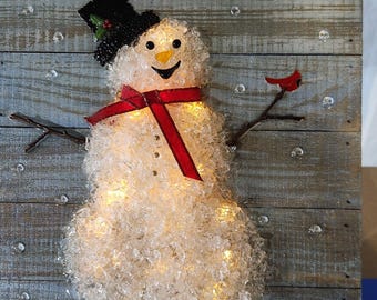 Crushed glass snowman covered in resin.