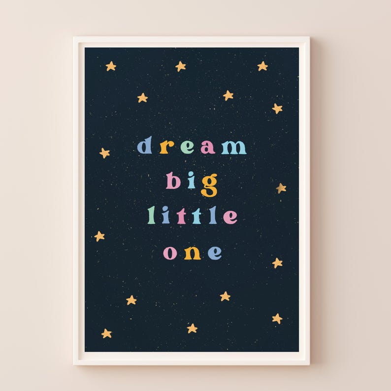 May include: A dark blue poster with gold stars and the text "dream big little one" in colorful letters.