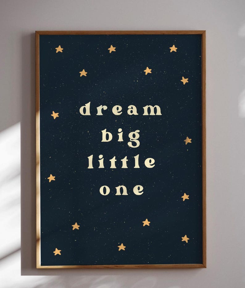May include: A dark blue poster with gold stars and the text "dream big little one" in white.
