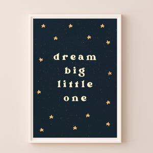 May include: A dark blue printable poster with gold stars and the text "dream big little one" in a light yellow font.