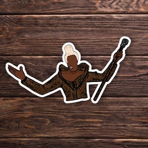 May include: A digital illustration of a person with blonde hair wearing a brown and black leopard print jacket and holding a microphone.