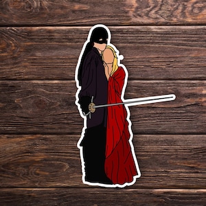 May include: A sticker featuring a black-clad figure with a mask holding a sword, standing next to a woman in a red dress.