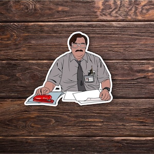 May include: A cartoon illustration of a man with glasses and a mustache sitting at a desk with a red stapler, papers, and a pencil. He is wearing a grey shirt and a black tie.