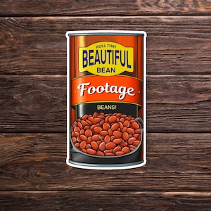 May include: A red and yellow can of "Roll That Beautiful Bean Footage" beans. The can has a picture of a bowl of red beans on the front.