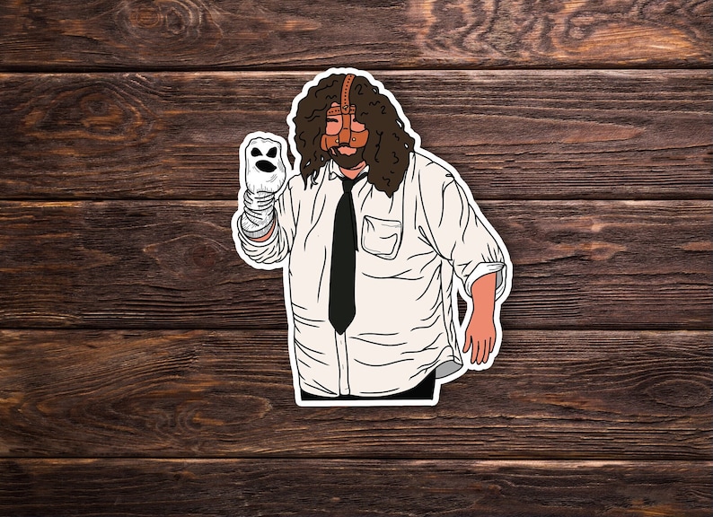 May include: A sticker of a person with long brown hair wearing a white shirt, a black tie, and a brown leather mask. The person is holding a white puppet with a smiling face.