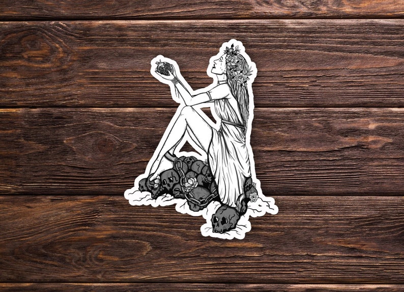 May include: A black and white illustration of a woman with a flower crown sitting on a pile of skulls. She is holding a heart in her hand and looking up.