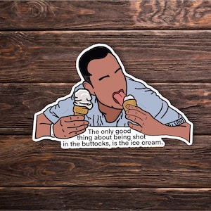 May include: A sticker featuring a cartoon illustration of a person eating two ice cream cones. The text on the sticker reads, "The only good thing about being shot in the buttocks, is the ice cream."