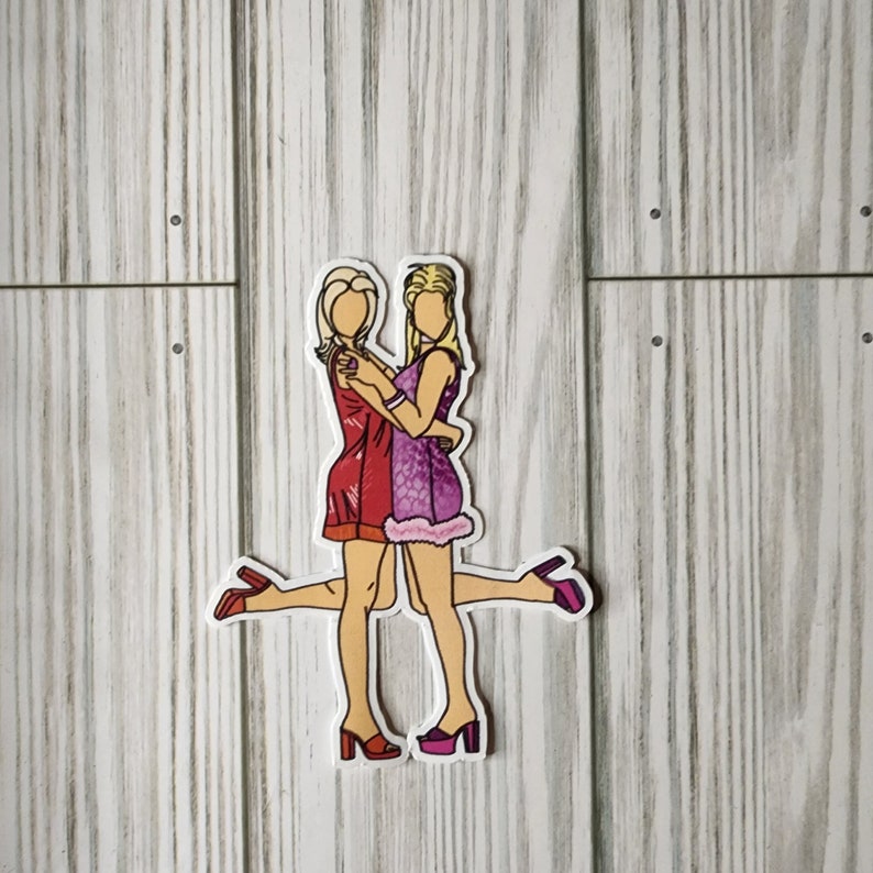 Pu&ograve; includere: Due donne in abito si abbracciano. La donna a sinistra indossa un abito rosso e la donna a destra indossa un abito viola con bordi bianchi. Entrambe indossano scarpe rosa.