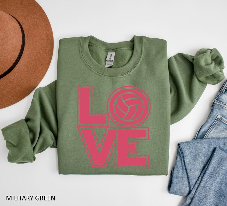 May include: A green sweatshirt with the word "LOVE" in pink letters, with a volleyball graphic in the "O".