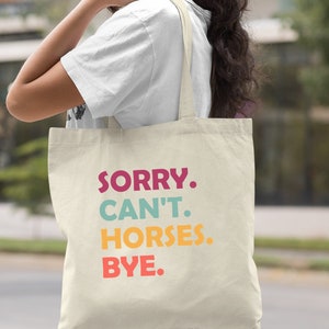 K&ouml;nnte beinhalten: Eine naturfarbene Canvas-Tragetasche mit dem Text "SORRY. CAN'T. HORSES. BYE." in bunten Blockbuchstaben.