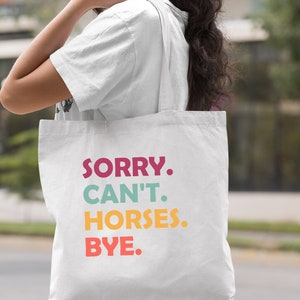 K&ouml;nnte beinhalten: Wei&szlig;e Stofftasche mit dem Text "SORRY. CAN'T. HORSES. BYE." in bunten Buchstaben.
