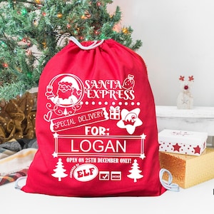 May include: A bright red drawstring gift sack featuring white printed graphics including a Santa Claus icon, the text SANTA EXPRESS, SPECIAL DELIVERY, FOR: LOGAN, OPEN ON 25TH DECEMBER ONLY, and ELF, along with star, gift, and pine tree illustrations.
