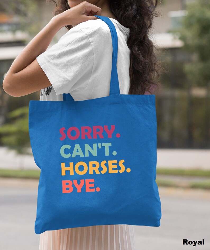 K&ouml;nnte beinhalten: Eine k&ouml;nigsblaue Tragetasche mit dem Text "SORRY. CAN'T. HORSES. BYE." in bunten Buchstaben.